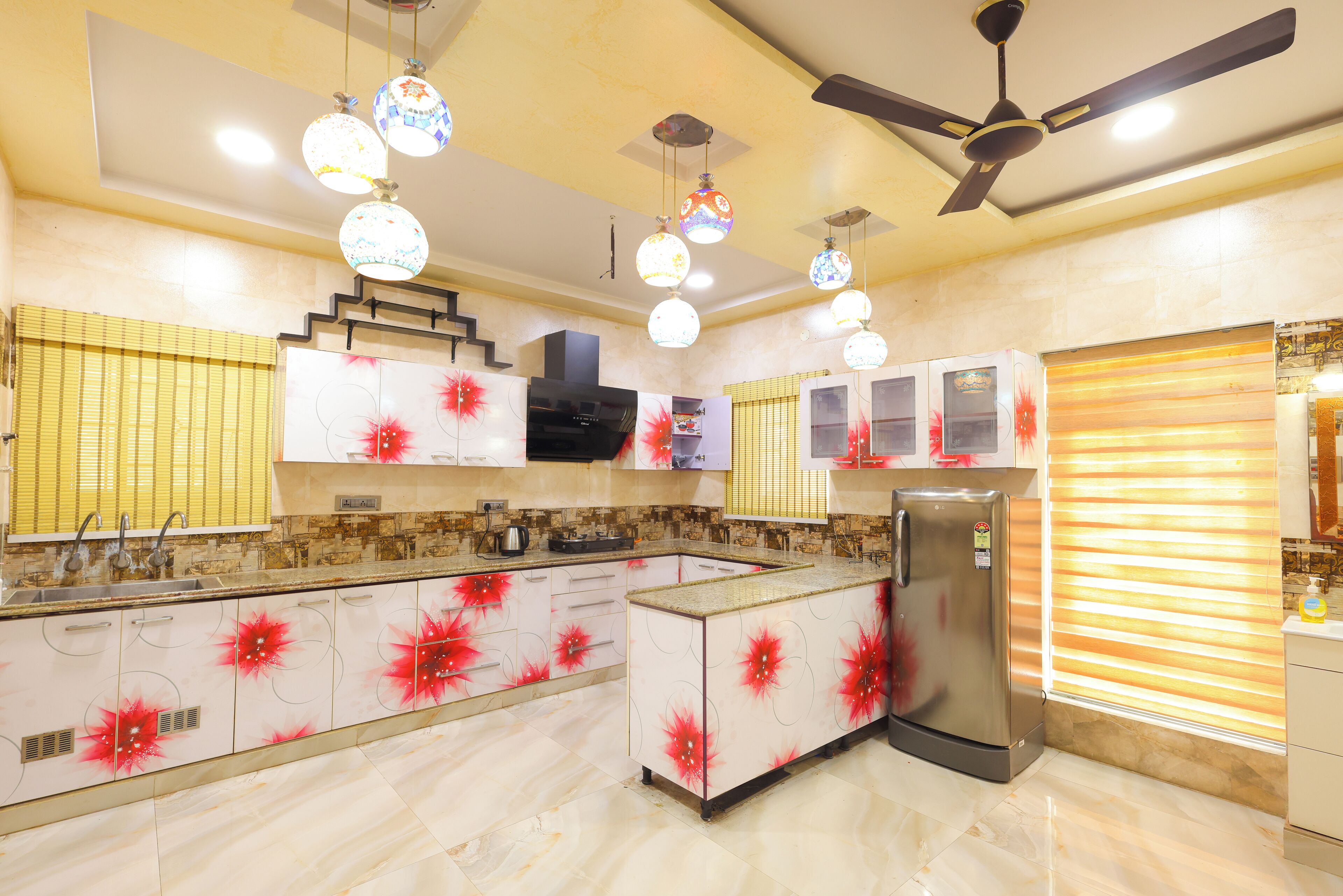 Una cocina moderna con una isla central, electrodomésticos de acero inoxidable e iluminación decorativa.