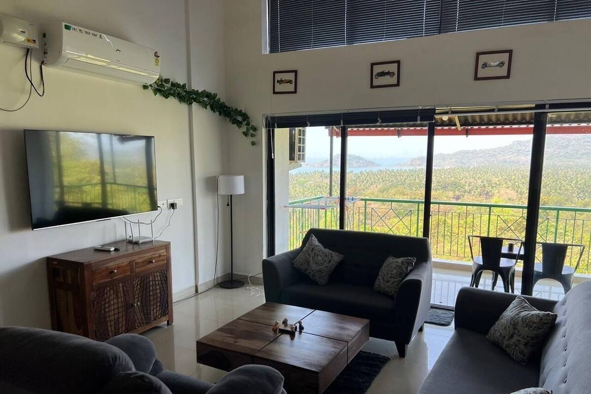 A modern living room with a flat-screen TV, a wooden cabinet, a sofa, and a coffee table.