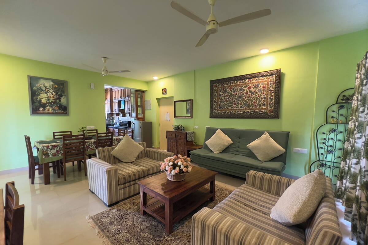 A living room with a sofa, chairs, a coffee table, and a dining area with a table and chairs.
