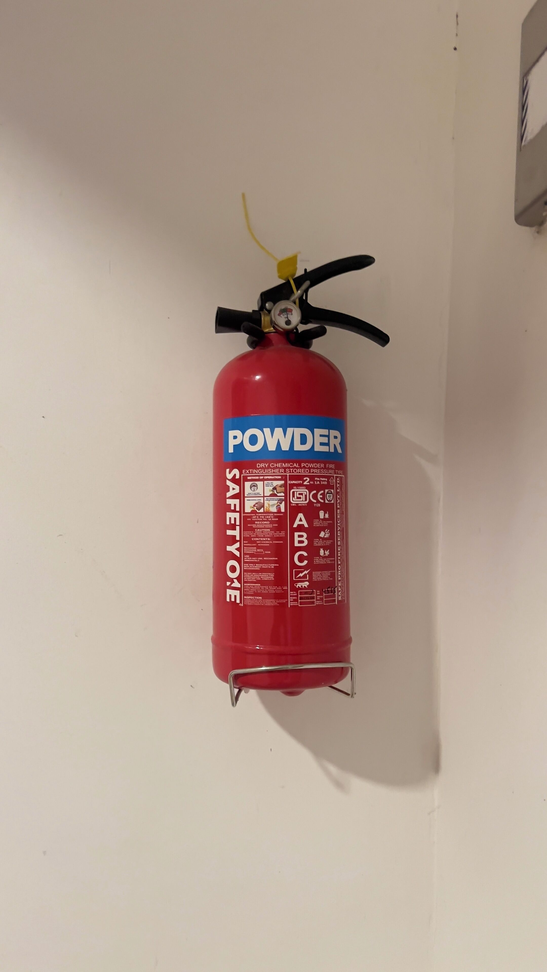 Un extintor rojo fijado en la pared.