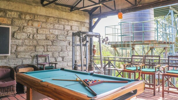 A pool table with a green felt surface, surrounded by wicker chairs and a wooden table. - MT LONGONOT COUNTRY RESORT NAIVASHA (Naivasha)
