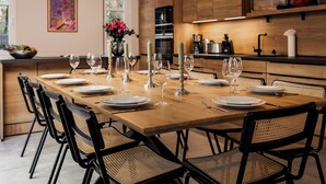 Een moderne eethoek met een houten tafel voor zes personen, omringd door zwarte stoelen met geweven zittingen.