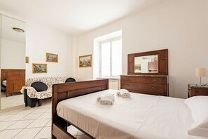 A bedroom with a bed, a dresser, a mirror, and a window. - Cosy flat with parking in Chiavari (Chiavari)