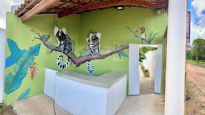 A mural of animals on a wall with a bench in front. - Casa Les Deux R da Lagoa (Jijoca de Jericoacoara)