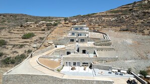 Un bâtiment moderne en pierre, à plusieurs niveaux, avec une allée sinueuse menant à l’entrée.
