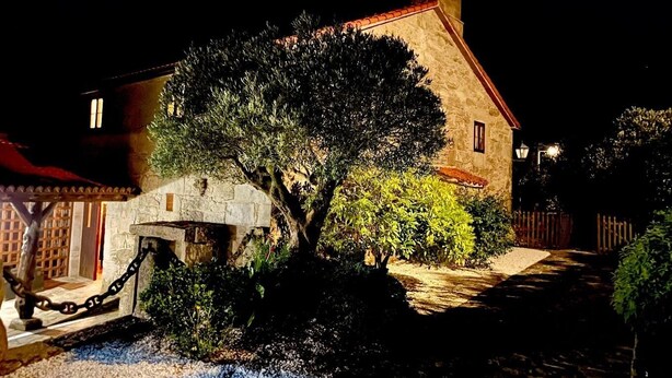 A stone building with a red roof, a small tree, and a gravel path leading to the entrance. - Val Fresco Suites & Relax (A Estrada)