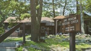 Señal del Centro de Actividades al Aire Libre AMC Mohican con instrucciones para registrar la visita.