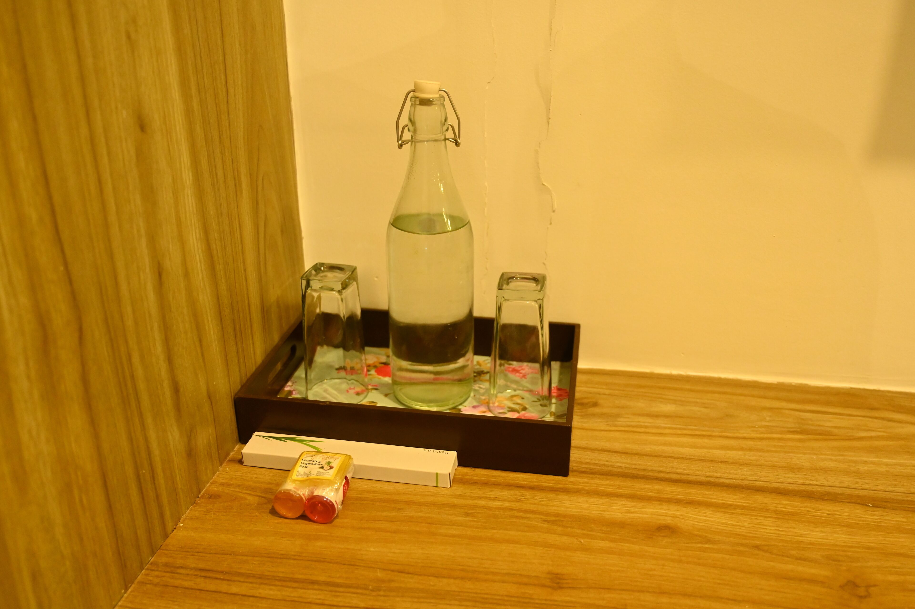 A wooden table with a glass bottle, two salt shakers, and a small box.