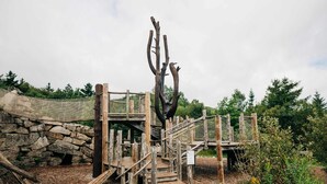 A wooden structure with a stone wall and a rope bridge. - Heart of the Presidential Range! Hiker Breakfast, Shared Bath, Trail Access (Bretton Woods)