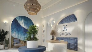 A modern reception area with a large wave painting, a reception desk, and a seating area with a round table and chairs.