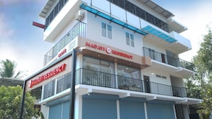 Ένα πολυώροφο κτίριο με μια πινακίδα που αναγράφει «Maday Residence» και «Δωμάτια».