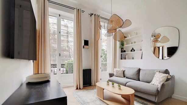 A modern living room with a sofa, coffee table, and a TV on a stand.