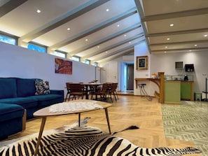 Relax in this stylish living area with a sofa, rug, and dining table.
