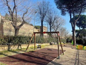 Children can play on the swing set and play structure in this outdoor playground.