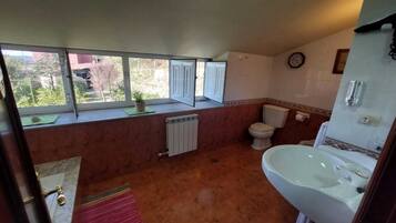 Une salle de bain avec des toilettes, un lavabo et une fenêtre.