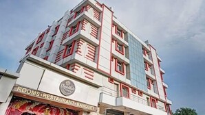 A multi-story building with a modern architectural design, featuring a prominent sign for 'Chocolate Inn' with a restaurant and banquet hall. - Saalt Patliputra Hotel (Patna)