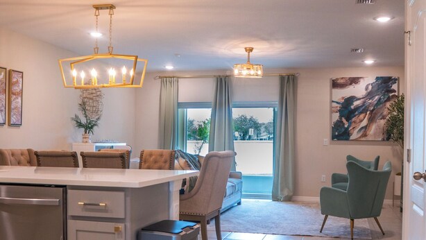 A modern kitchen with a central island, stainless steel appliances, and a hanging light fixture. - Magical Moments Retreat: Your Family’s Gateway to Central Florida Fun (Kissimmee)
