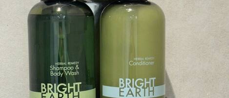 Duas embalagens de shampoo e condicionador Bright Earth fixadas numa parede.