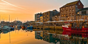 A harbor with boats docked, buildings with balconies, and a clear sky. - Admiralty Retreat by Pureserviced (Plymouth)