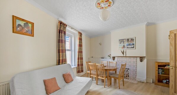 A cozy living room with a sofa, wooden dining table, and chairs. - Admiralty Retreat by Pureserviced (Plymouth)