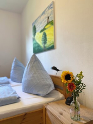 Cozy retreat with a single bed, nightstand, and a beautiful landscape painting.