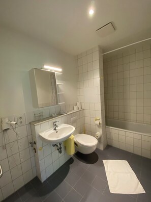 Bathroom features a sink, mirror, toilet, and bathtub.