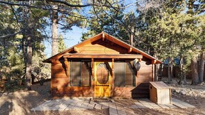 A small wooden cabin with a front door, two windows with shutters, and a small porch area. - Charming Mountain Getaway (Sugarloaf)