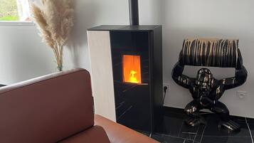 Een moderne woonkamer met een bank, een open haard en een decoratieve stoel.