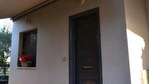 A modern building with a flat roof, a dark-colored door, and a small window with flowers. - Nafpaktos Cozy Nest Homely Vibes Near the Beach (Nafpaktos)