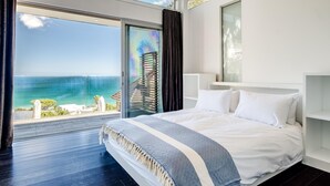A bedroom with a large bed, a view of the ocean, and a balcony. - 3bed Apt 4-min to Llandudno Beach Backline Views (Cape Town)