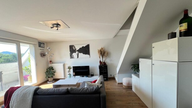 Una sala de estar moderna con un sofá, televisión y un ventilador de techo.