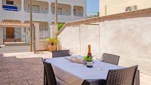 An outdoor patio with a table set for two, a bottle of champagne, and a potted plant. - Villa Porto Cesareo Con Parcheggio (Porto Cesareo)