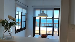 A bathroom with a large window overlooking a pool and the sea. - Apartment with sea views and private pool (Llançà)