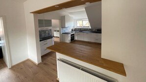 Eine moderne Küche mit weißen Schränken, einer Holzarbeitsplatte und einem eingebauten Backofen.