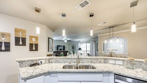 A kitchen with a granite countertop, stainless steel sink, and white cabinetry. - San Antonio Condo: 10 Mi to Dtwn! (San Antonio)