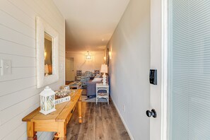 A hallway with a wooden bench, a white lantern, and a wall-mounted mirror. - Walk to Beach: Newly Remodeled Condo in Ocean City (Ocean City)