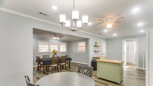A spacious kitchen with a dining area, wooden flooring, and a ceiling fan. - Near Shops & Eats: Home w/ Large Yard in Waycross! (Waycross)