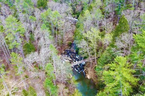 An aerial view of a forested area with a bridge over a river. - Sol & Luna: Luxury Cabin, Mountain Views, Hot Tub (Ellijay)