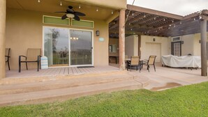 A covered patio area with outdoor seating, a ceiling fan, and a pergola with string lights. - Walk to Colorado River: Needles Gem w/ Pool Access (Needles)