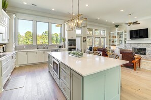 A spacious kitchen with a large island, built-in appliances, and ample natural light from large windows. - Luxe Golf Getaway in Hot Springs Village! (Hot Springs Village)
