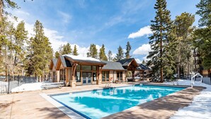 A resort with a swimming pool, wooden cabins, and a snowy landscape. - Studio in Great Area, Easy Walk to Town & Peak 9 (Breckenridge)