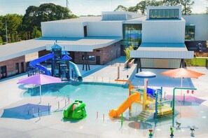 Ein modernes Gebäude mit Schwimmbad und Wasserrutschen.