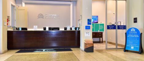 A reception area with a reception desk, a signboard, and directional signs for the building's towers.