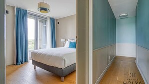 Ein Schlafzimmer mit Bett, Vorhängen und einer Deckenleuchte.