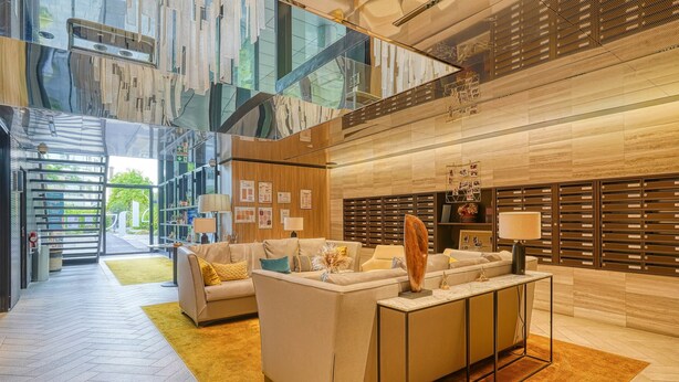 Eine moderne Lobby mit einer Couch, einem Couchtisch und einer Rezeption.