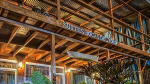 Un edifici de fusta amb un cartell que diu "SUITES BOCAS DEL TORO".