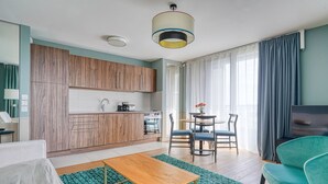 A modern living room with a wooden cabinet, a dining table with chairs, a sofa, and a TV.