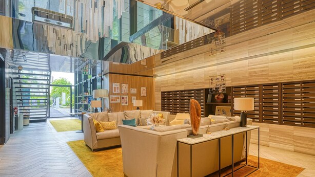Un hall d’entrée moderne avec un canapé, une table basse et un comptoir d’accueil.