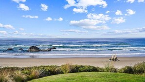 A beach with waves, a clear sky, and some rocks. - Left Coast Hideaway - New Listing! (Cannon Beach)