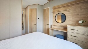 A bedroom with a bed, a dresser, a mirror, and a wardrobe. - Host & Stay | Grange (Morecambe)